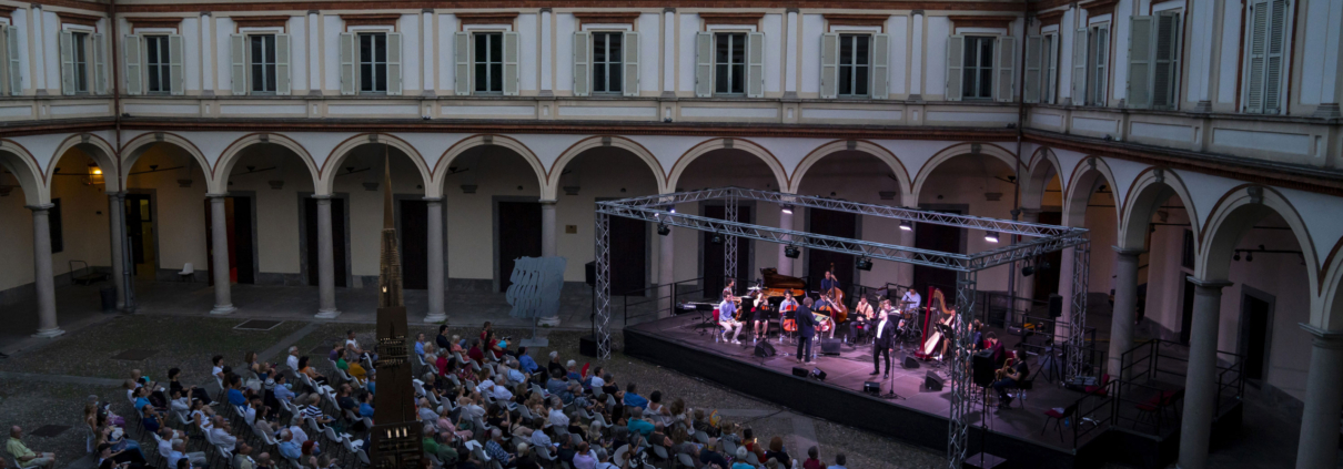 Chiostro di sera con orchestra che suona sul palco
