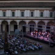 Chiostro di sera con orchestra che suona sul palco